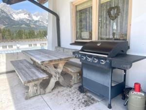 a grill and a picnic table on a patio at Villa Edyta Ellmau in Ellmau