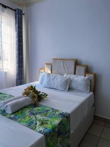 a bed with two pillows and flowers on it at Stunning 2 Bedroom Apartment in Mombassa in Mombasa
