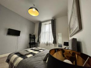 1 dormitorio con cama y ventana en City Lights Apartment en Edimburgo