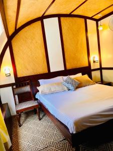 een slaapkamer met een groot bed en een stoel bij Thara's Houseboat in Alleppey