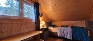 a small bedroom with a bed in a wooden cabin at Kolej na sudety in Leszczyniec