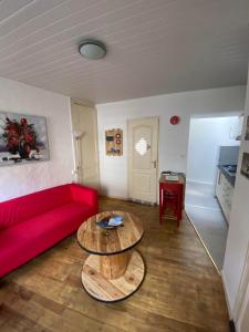 - un salon avec un canapé rouge et une table dans l'établissement LA PERLE MARINE :Boulogne sur mer, à Boulogne-sur-Mer
