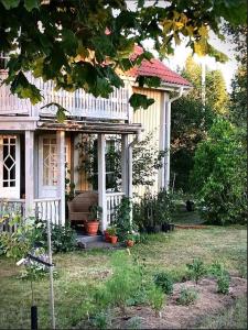 a small house with a white fence and a porch at Hus från 1800-talet med tre eldstäder in Lönashult