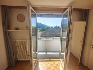 a room with a large glass door with a clock at 2 bedroom Apartment at Bahnhofcity in Feldkirch