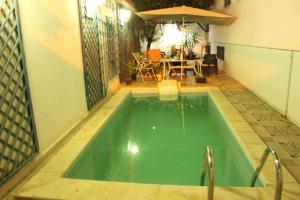 a small swimming pool with a table and an umbrella at Dar Sarra in Sousse