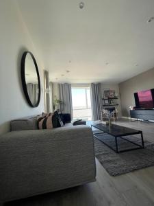 sala de estar con sofá y espejo en Stylish Large Flat in perfect location with Private Balcony and Sea View in Dublin 5 en Dublín