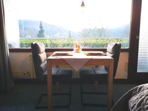 une table à manger avec deux chaises et une fenêtre dans l'établissement Apartment in Bad Grund (Harz), à Bad Grund