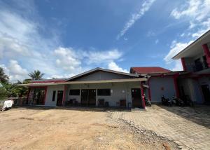 a white house with a red roof at Steze Guesthouse Syariah Telanaipura in Jambi