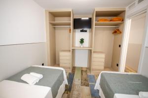 Habitación pequeña con 2 camas y TV. en Emalco 1-8 Centro Beach, en Benidorm