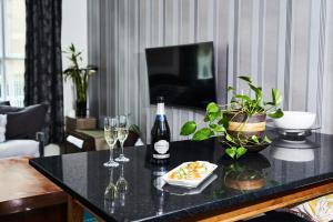 a living room with a table with wine glasses and plants at Satori Serviced Apartments in Manchester