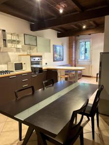 eine große Küche mit einem Tisch und Stühlen in der Unterkunft Appartamento - casolare Bologna in Bologna