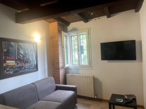 ein Wohnzimmer mit einem Sofa und einem Flachbild-TV in der Unterkunft Appartamento - casolare Bologna in Bologna