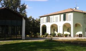 a large white building with a grassy yard at Hotel Riviera Ristorante La Briciola in San Bernardino