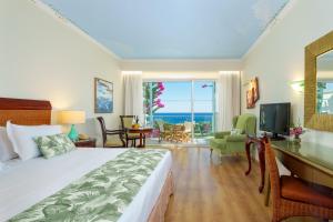 1 dormitorio con 1 cama y escritorio con TV en Atrium Prestige Thalasso Spa Resort & Villas en Lakhania