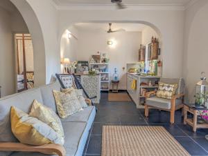 a living room with a gray couch and chairs at Villa Candolim in Candolim