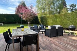 een patio met een tafel en stoelen en een grill bij Villa Bonheur sur Marne Near Disneyland in Claye-Souilly