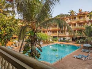 a swimming pool in front of a large building at Villa Candolim in Candolim