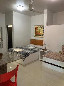 a bedroom with a bed and a table and a chair at Hotel Pousada Casuarinas in Recife