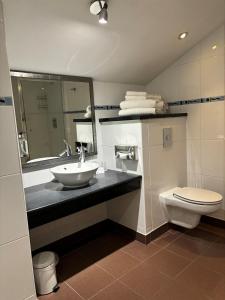 ein Bad mit einem Waschbecken und einem WC in der Unterkunft Holiday Inn Ellesmere Port/Cheshire Oaks, an IHG Hotel in Ellesmere Port