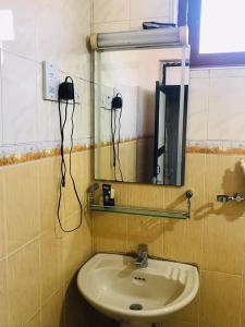 La salle de bains est pourvue d'un lavabo et d'un miroir. dans l'établissement Esplanade residence, à Matara