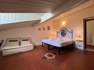 een slaapkamer met een bed en een bank erin bij La Terrazza di Shelley Panoramic Flat in Lerici