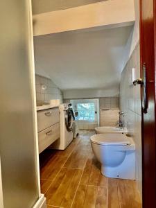 een badkamer met een toilet, een wastafel en een wasmachine bij La Terrazza di Shelley Panoramic Flat in Lerici