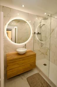 La salle de bains est pourvue d'un lavabo et d'un miroir. dans l'établissement Parisian style apartment, à Maisons-Alfort