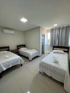 sypialnia z 2 łóżkami i oknem w obiekcie Hotel Brisas w mieście Bom Jesus da Lapa