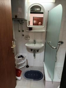a small bathroom with a sink and a mirror at Apartmani Jelena in Vrnjačka Banja +28 photos