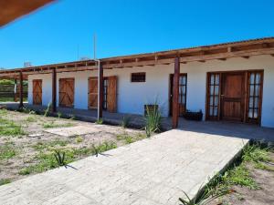 eine Außenansicht eines Hauses mit Holztüren in der Unterkunft La Blanca in Mercedes