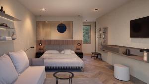 a bedroom with a bed and a couch and a tv at Exclusive Boutique Hotel Elisabetta in Ronco sopra Ascona