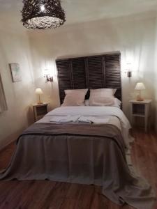 a bedroom with a large bed with a wooden headboard at St Martin du Canigou in Casteil
