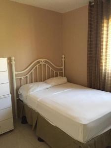 - un lit blanc dans une chambre avec fenêtre dans l'établissement Appartamento Mustique Juan Dolio fronte mare, à Juan Pedro