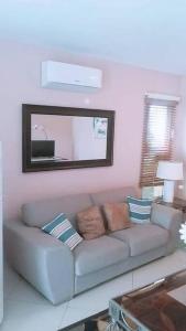 - un salon avec un canapé et un miroir dans l'établissement Appartamento Mustique Juan Dolio fronte mare, à Juan Pedro