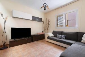 a living room with a couch and a flat screen tv at Casa La Herradura in Telde