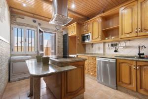 a kitchen with wooden cabinets and a counter top at Casa La Herradura in Telde