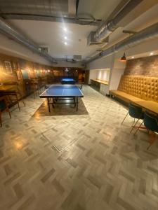 a ping pong table in a room with chairs at Vitality Hotels in Birmingham
