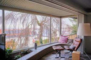 a screened in porch with a couch and a large window at ZeitweiseHaus in Weingarten