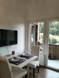 a dining room with a table and chairs and a window at Le Sorelle Apartments 2 in Ferden