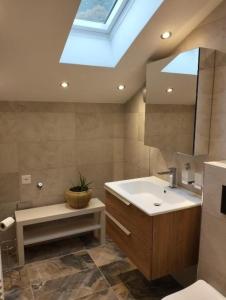 a bathroom with a sink and a skylight at Le Sorelle Apartments 2 in Ferden