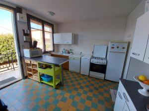 eine Küche mit weißen Geräten und Fliesenboden in der Unterkunft Grande maison proche plage et marché in Saint-Cyprien