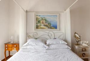 ein Schlafzimmer mit einem weißen Bett und einem Gemälde an der Wand in der Unterkunft Affascinante appartamento nel Castello. in Moniga