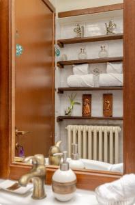 ein Badezimmer mit einem Waschbecken, einem Spiegel und Handtüchern in der Unterkunft Affascinante appartamento nel Castello. in Moniga