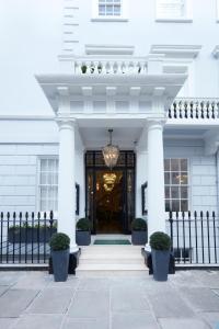 een wit gebouw met een zwarte poort en een deur bij 2 Chesham Hotel in Londen