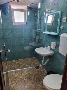 a bathroom with a sink and a toilet and a mirror at Studios Kalina in Budva +74 photos