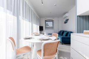 un comedor blanco con una mesa y sillas blancas en HEVENIA POGORZELICA - APARTAMENT 1, en Pogorzelica