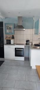 a kitchen with white appliances and a tile floor at charmant petit appartement en Alsace in Bouxwiller