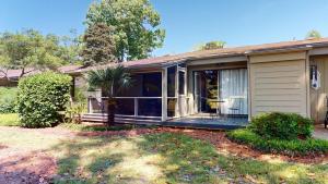 a house with a screened in porch with a yard at Escape to Magnolia Run 2 Bedroom Golf Villa in Pawleys Island