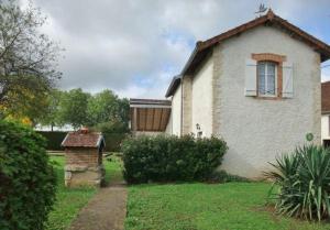 una casa blanca con una ventana en un patio en Gîte Ai Ouillotte en Bétoncourt-les-Ménétriers