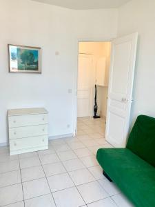 a living room with a green couch and a bedroom at Festival de Cannes apartment in Cannes